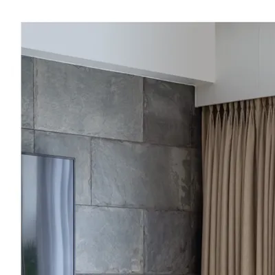 A detail shot showing the clean lines where the slate stone wall meets the ceiling. This precision and attention to architectural detail is a hallmark of our work.