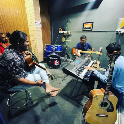 A full band setup during a group learning session in our HSR Layout jam room. You can see the drum kit, keyboard, and multiple guitarists comfortably collaborating in the space.