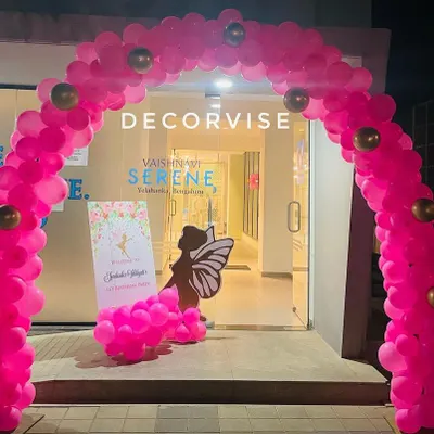 A stunning entrance for a butterfly-themed party, featuring a full arch of bright pink balloons. This grand entryway immediately immerses guests in the celebration's magical atmosphere.