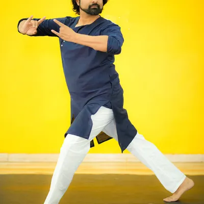 A portrait capturing a moment of quiet contemplation and movement. The vibrant yellow background contrasts with the calm yet powerful posture, reflecting the dynamic nature of dance.