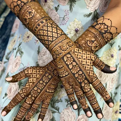 An elegant criss-cross pose showing a beautiful design with floral bands and intricate check patterns on the arms.