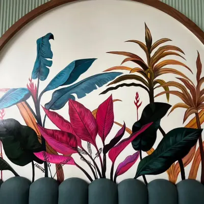 The final look of the tropical headboard mural, featuring a rich palette of deep greens, vibrant pinks, and earthy browns. This botanical wall art serves as a stunning focal point in the bedroom.