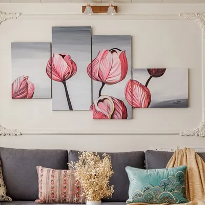This multi-panel floral artwork adds a soft, artistic touch above the sofa. The piece is complemented by a mix of textured cushions and a cozy throw, demonstrating how art and textiles can work together.