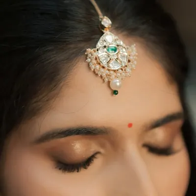 A macro shot of the eye makeup. I focus on creating a clean, blended look with a touch of shimmer, finished with a traditional bindi for a classic touch.