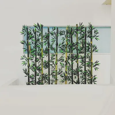 This installation uses artificial bamboo stalks to create a natural-looking screen in a minimalist, modern space. It adds texture and a sense of tranquility while separating the area.