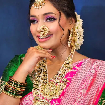A radiant Maharashtrian bride, embodying grace and tradition. I created this look with vibrant pink eyeshadow to match her saree and a classic nath that completes the look.