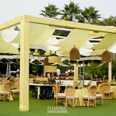 A wide view of our "Tiny Hive" baby shower, featuring a custom canopy with yellow and white striped fabric, creating a bright and airy atmosphere.