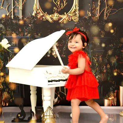 A candid moment at the piano. Dressed in a vibrant red dress, she creates her own sweet melody in this elegant, musically-inspired photoshoot.