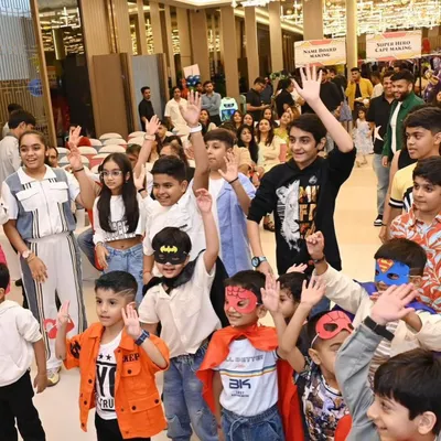 A room full of happy little superheroes with their hands in the air, completely absorbed in the party entertainment.