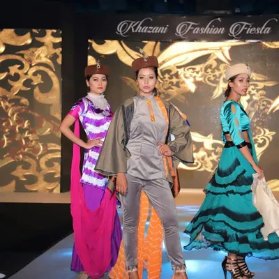 Models present a collection featuring a mix of modern silhouettes and traditional Indian textiles at our annual Khazani Fashion Fiesta. This look combines a grey velvet co-ord set with a bandhani-style dupatta, demonstrating a fusion of styles.