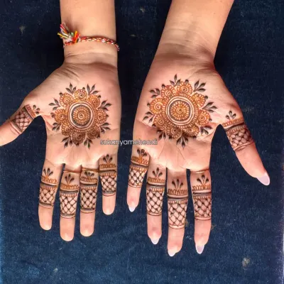 A simple and elegant Mandala mehendi. The design features a central floral mandala on each palm with matching intricate patterns on the fingertips.