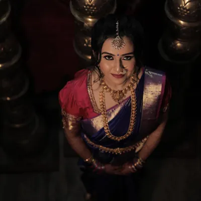 Chinmayi's varpooje look was absolutely captivating. We went for a dramatic smokey eye and a soft pink lip to complement her royal blue and pink Kanjeevaram saree.