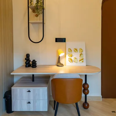A compact and stylish study nook from the 'Sukoon' project, featuring a custom desk with unique spherical leg detail.