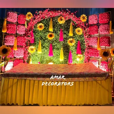A closer look at this popular Mehendi backdrop, where the bright yellow of the seating and tassels pops against the pink and green floral wall. It’s a design that guarantees vibrant photos and a festive mood.