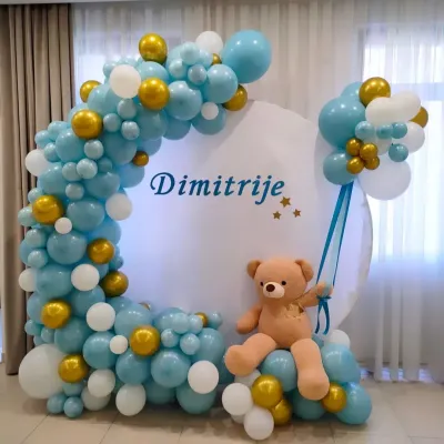 A lovely teddy bear theme for baby Dimitrije. This setup features a crescent-shaped balloon arch in blue, white, and gold around a personalized circular backdrop.
