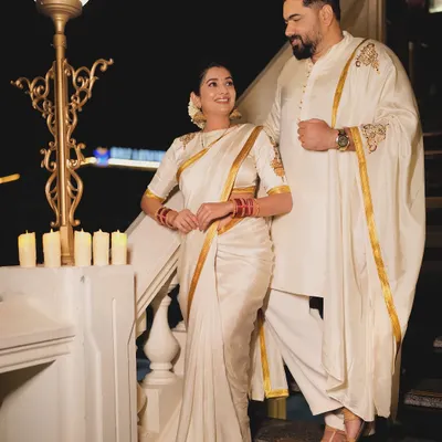 For their first Diwali, I designed these coordinated white and gold outfits for Tharun Sudhir and Sonal Monteiro. Her saree blouse and his kurta both feature the same custom hand-painted gold motif, creating a look that is connected and elegant.