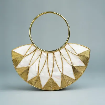 This fan-shaped brass clutch is a personal favorite, featuring an elegant art deco inspired design. The combination of mother of pearl inlay and fine brass wirework is complemented by a chic circular handle.