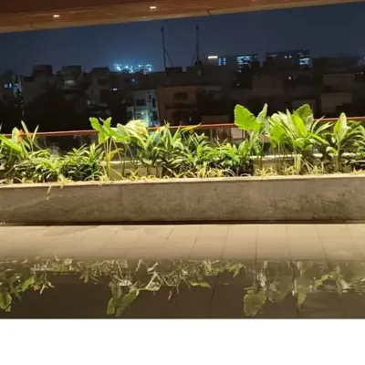 A terrace garden isn't just for the daytime. This setup, with its built-in planters, comes alive at night, offering a stunning view of the city and a tranquil place to unwind after a long day.