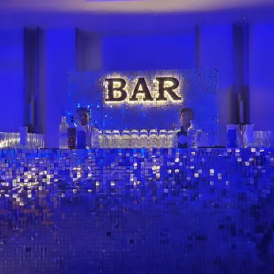 Our silver shimmer bar adds a touch of disco glamour to any party. Lit with a cool blue light and a bold 'BAR' sign, this setup is perfect for sangeets, milestone birthdays, or any event that needs a vibrant, high-energy focal point.