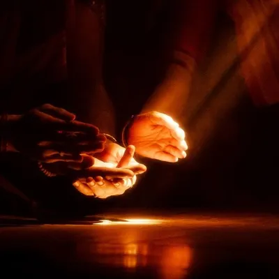 A moment from 'Naga Mandala' where light is used as a narrative tool. The single beam of light on the hands creates a focal point of intense drama.