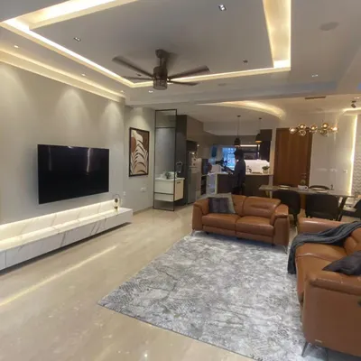 This wide shot shows an open-plan living and dining area. I used consistent flooring and a neutral color palette to unify the space, while leather sofas add a touch of warmth and luxury.