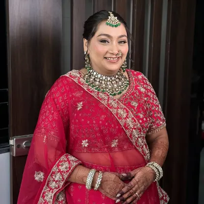 A beautiful, happy bride in a classic red lehenga. I created a soft glam look with defined eyes and a natural, dewy skin finish that complements her emerald jewellery.