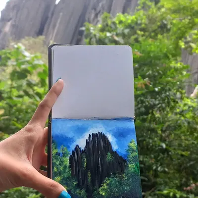 An acrylic painting of the unique karst rock formations at Yana, created on location. Holding the finished piece against the scenery shows how I translate real-life landscapes into art.