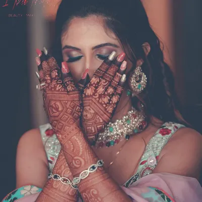 A creative shot capturing the intricate mehendi and the vibrant carnival-themed makeup. I used bold pink and purple eyeshadows to create a fun and festive look for this pre-wedding event.