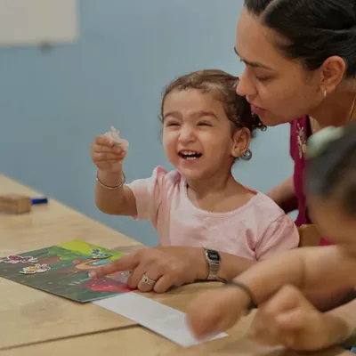 The pure joy of discovery on a child's face is our greatest reward. Here, a little learner is completely absorbed in a puzzle, a simple activity that builds critical thinking, problem-solving skills, and patience.