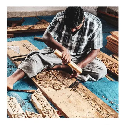 A carpenter meticulously carves a detailed pattern for a door at one of our residential projects. This image captures our commitment to hands-on involvement and the celebration of skilled artisanship.