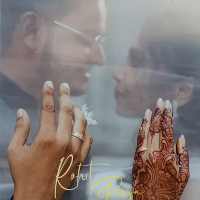 A creative engagement ring shot, focusing on the couple's hands against the backdrop of their faces seen through a sheer veil.