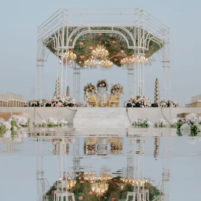 For this seaside wedding, I designed a modern white mandap with a fully mirrored aisle. The reflection of the structure, the sky, and the ceremony created a stunning, symmetrical vision of beauty and union.