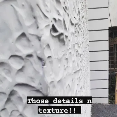 I love the beauty found in details and texture. This image shows a close-up of a textured wall finish, which adds a unique, tactile quality to the building's exterior and elevates the overall design.