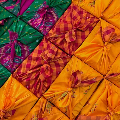 This is my favorite way to wrap. We use beautiful old sarees, sent by the client or sourced by us, and tie them in the Japanese Furoshiki style. It’s a completely waste-free method that turns the packaging into a reusable gift itself.