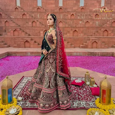 A full view of a majestic bridal lehenga against a stunning backdrop. The deep velvet and detailed embroidery make this a truly royal choice for any bride.