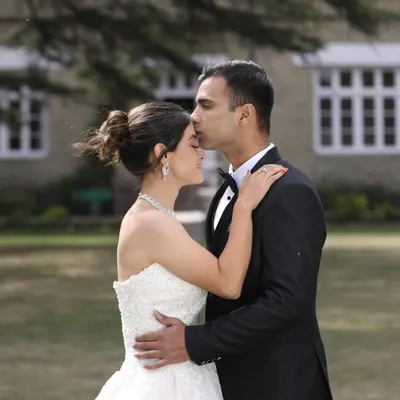 A classic pre-wedding portrait that exudes romance. The combination of formal wear, a beautiful outdoor setting, and a tender gesture creates a truly timeless couple shoot.