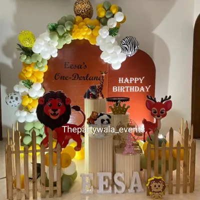 A 'One-Derland' wild jungle theme with a warm, earthy color palette. The setup includes lion and deer cutouts and a custom arch backdrop.