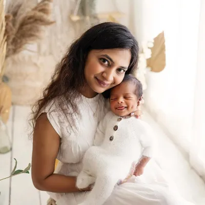 Just look at that dimple! This beautiful mom is holding her smiling baby, and the connection between them is just radiant.