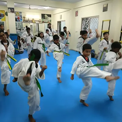 A class of green belts practicing their front kicks (Ap Chagi) in unison, building power and precision with every movement.