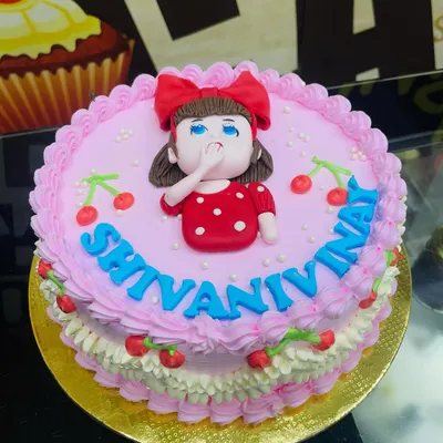 A lovely 1kg pink cake with a simple piped border and a cute fondant girl topper.