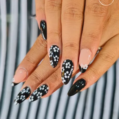 A classic black and white design with a twist. This set features a mix of solid black, a French tip, and a delicate daisy pattern, showing how simple elements can create a chic and coordinated look.