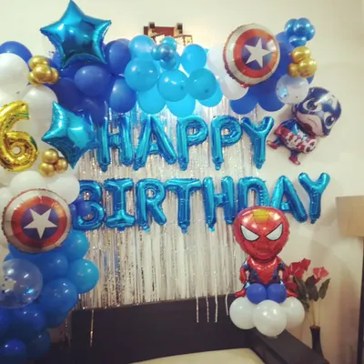 A superhero themed birthday party perfect for a young fan. This bedroom setup includes character balloons like Spiderman and Captain America, star-shaped foils, and a "Happy Birthday" banner in bold blue.