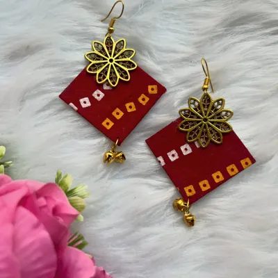 These handmade red fabric earrings with a bandhani-style print and a gold flower charm are lightweight and perfect for adding a pop of color to your casual wear.