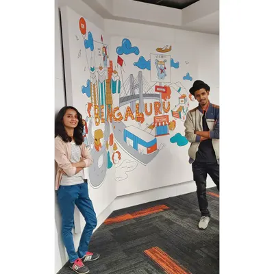 Posing with our finished mural for Xiaomi India's office in Bengaluru. This custom doodle art covers a corner wall and is filled with icons that celebrate the city.