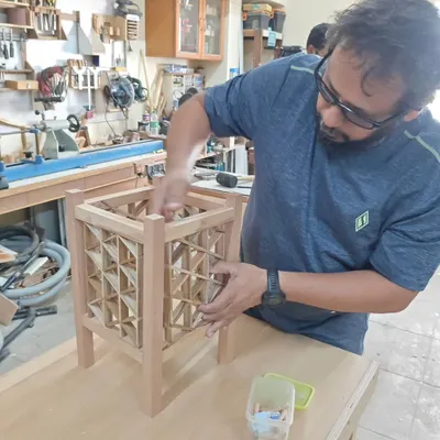 Here's a student working on a triangle grid Kumiko lamp. This technique requires immense focus as each small piece is carefully fitted. It's a rewarding process that results in a truly unique piece of decor.