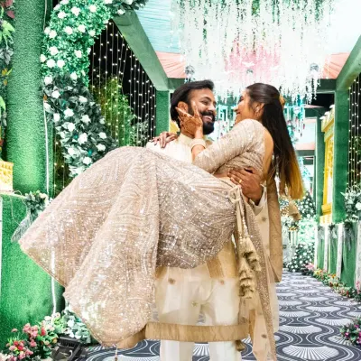 A playful and romantic lift. This kind of shot captures the fun and loving dynamic between the couple, set against the beautiful backdrop of their Sangeet decor.