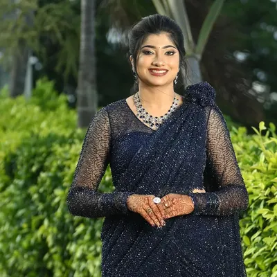 A vision of evening elegance. This client is ready for any gala in a sparkling navy blue saree. The full sleeved sheer blouse is covered in matching beadwork, creating a sophisticated and glamorous look.