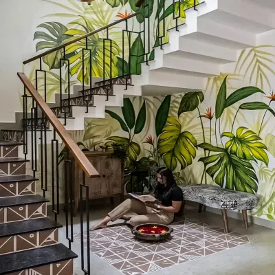 We turned the often-neglected space under a staircase into a charming reading nook. The vibrant, hand-painted tropical mural and patterned floor tiles create a delightful and cozy corner to escape with a book.