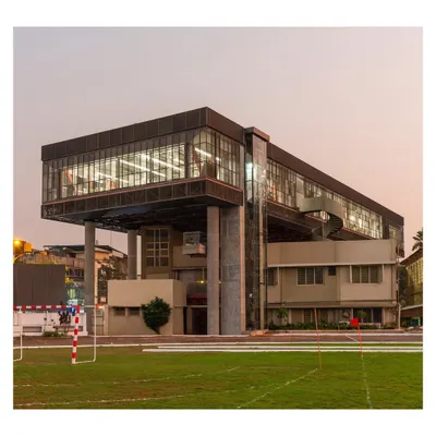 The Hoverspace project viewed from the adjacent sports ground at dusk. The design creates a new visual anchor for the campus, with the illuminated interior revealing the steel truss structure that makes the cantilever possible.