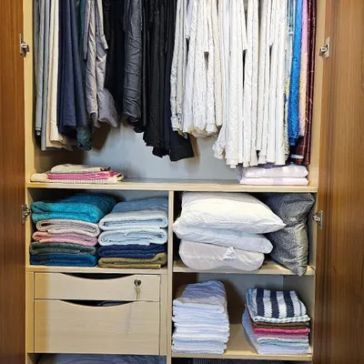 A linen closet in all its glory. Have you tried hanging your bedsheets? It's a game-changer for visibility and preventing wrinkles. This is a soothing corner we create in every home.